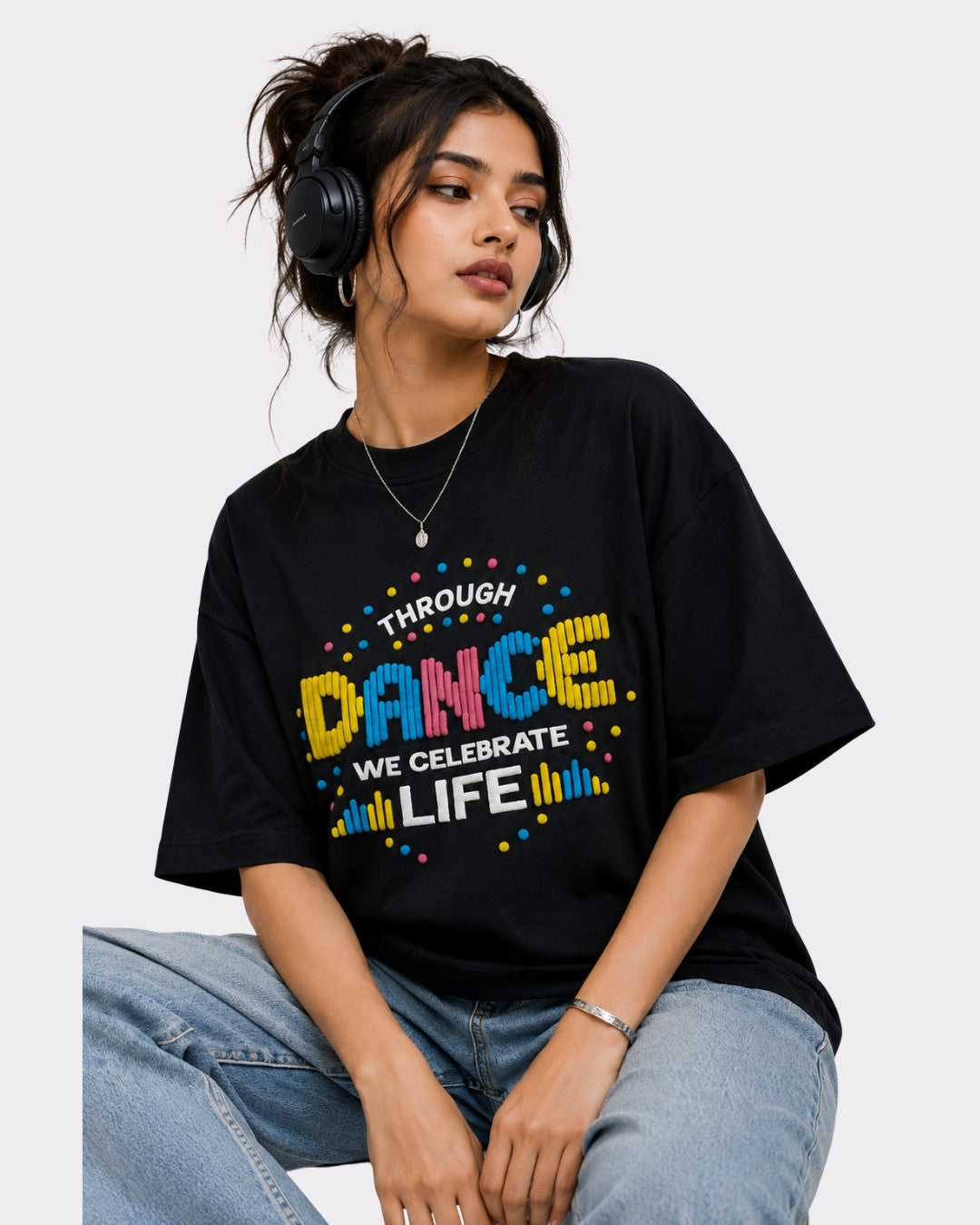 Dancer Oversized T-shirt For Women in black with colorful dance graphic worn by woman with headphones