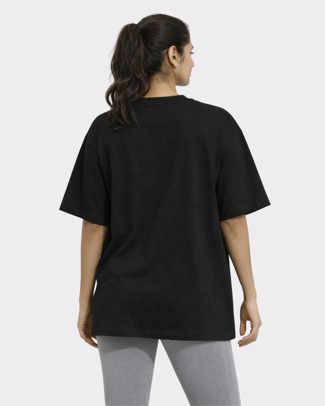 Back view of woman wearing black Yoga Oversized T-shirt For Women from Bandar Baant Collections