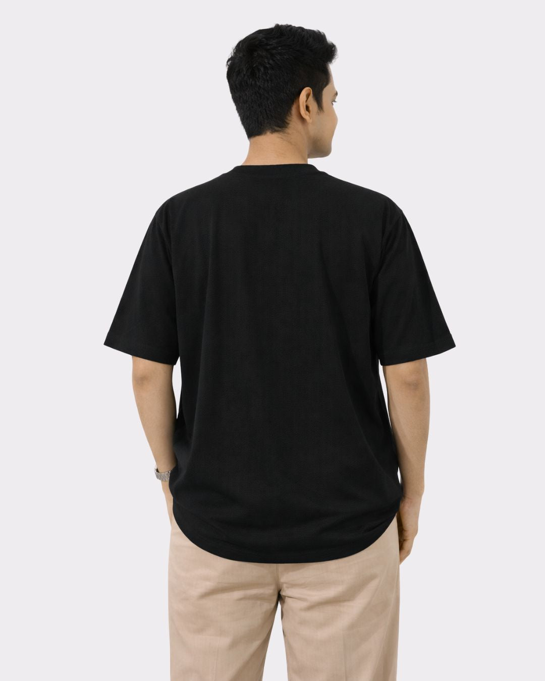 Back view of a man wearing a black oversized fit Tshirt from Bandar Baant Collections Chartered Accountant Trendy Tshirt For Men
