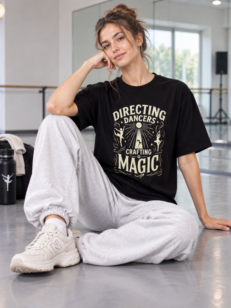 Oversized fit black Choreographer T-shirt For Women with directing dancers graphic worn by seated woman