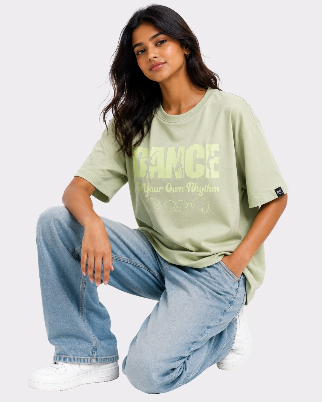 Dance to Your Own Rhythm Oversized T-shirt For Women in light green worn by a woman with denim jeans and white sneakers