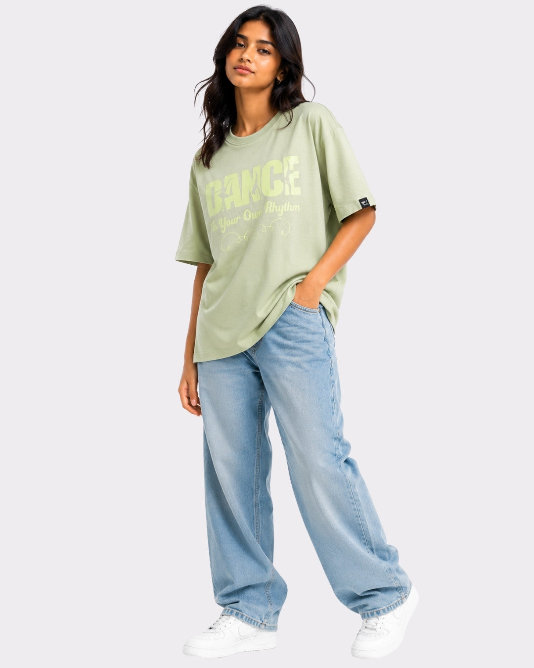 Dance to Your Own Rhythm Oversized T-shirt For Women in light green styled with wide leg jeans and white sneakers