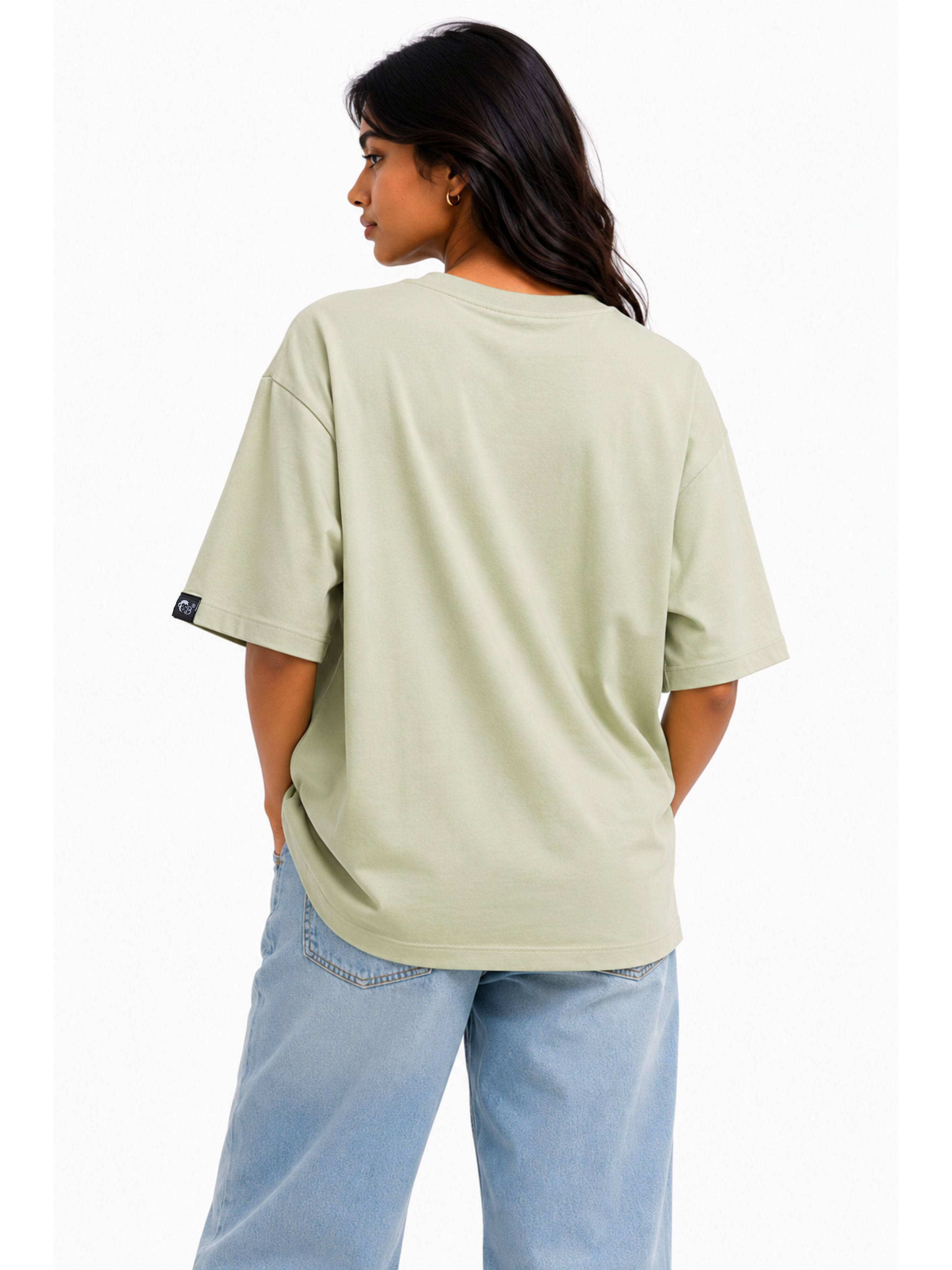 Back view of a model wearing a green Dancer Oversized T-shirt For Women from Bandar Baant Collections paired with light blue jeans