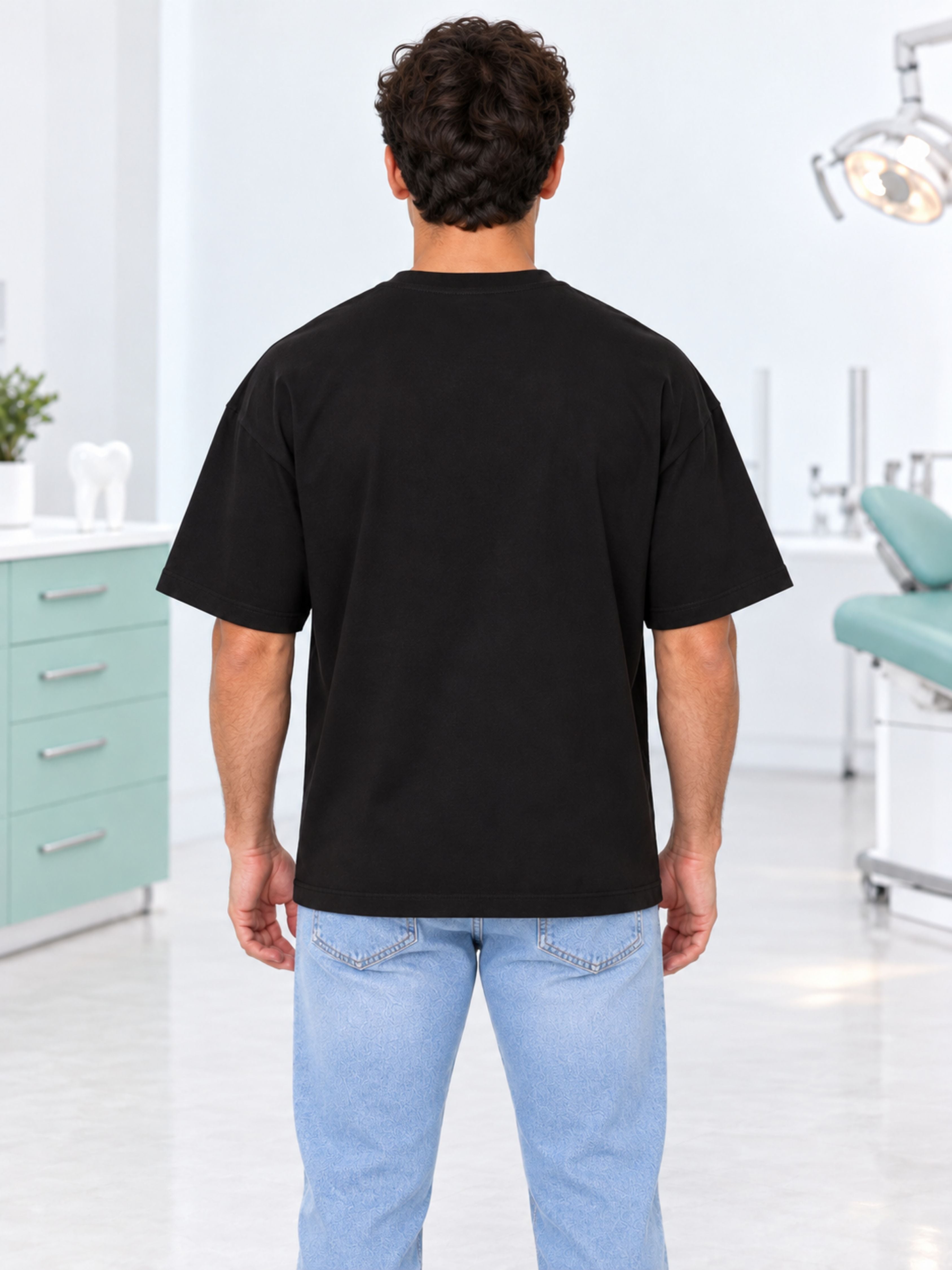 Back view of a man wearing a black oversized fit Dentist Quirky T-shirt For Men by Bandar Baant Collections