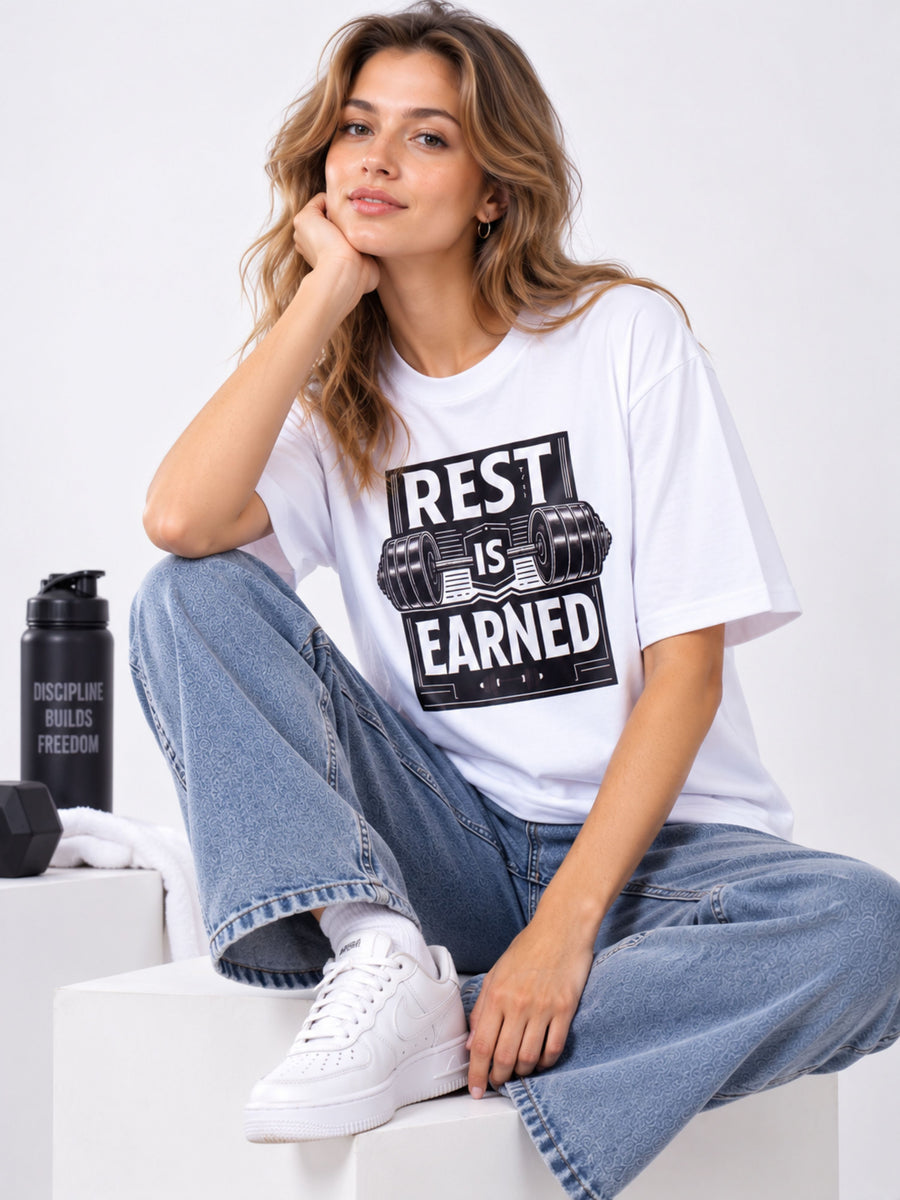 Fitness Trainer T Shirt For Women oversized fit white tee with rest is earned slogan worn by woman