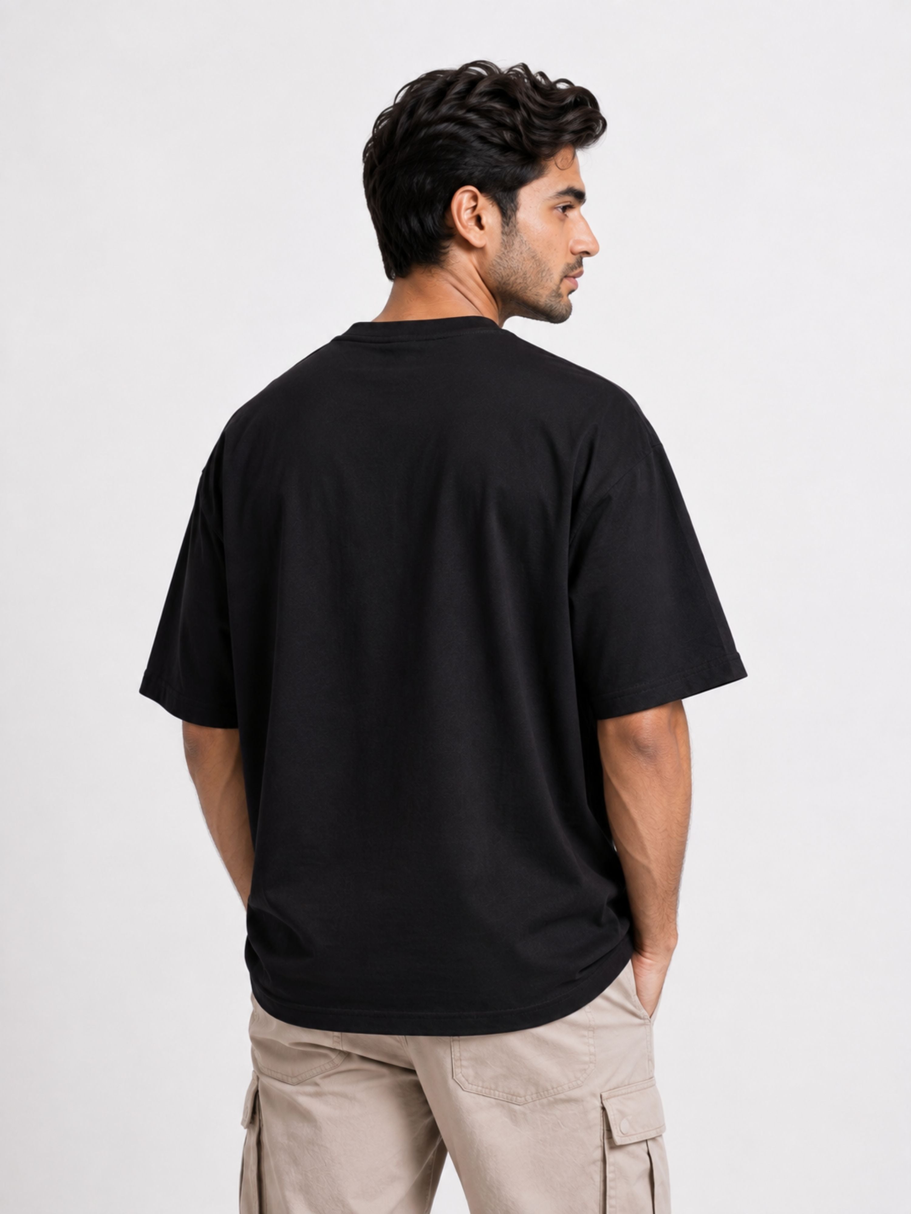Back view of a man wearing a black oversized fit Gynaecologist Quote Tshirt For Men from Bandar Baant Collections