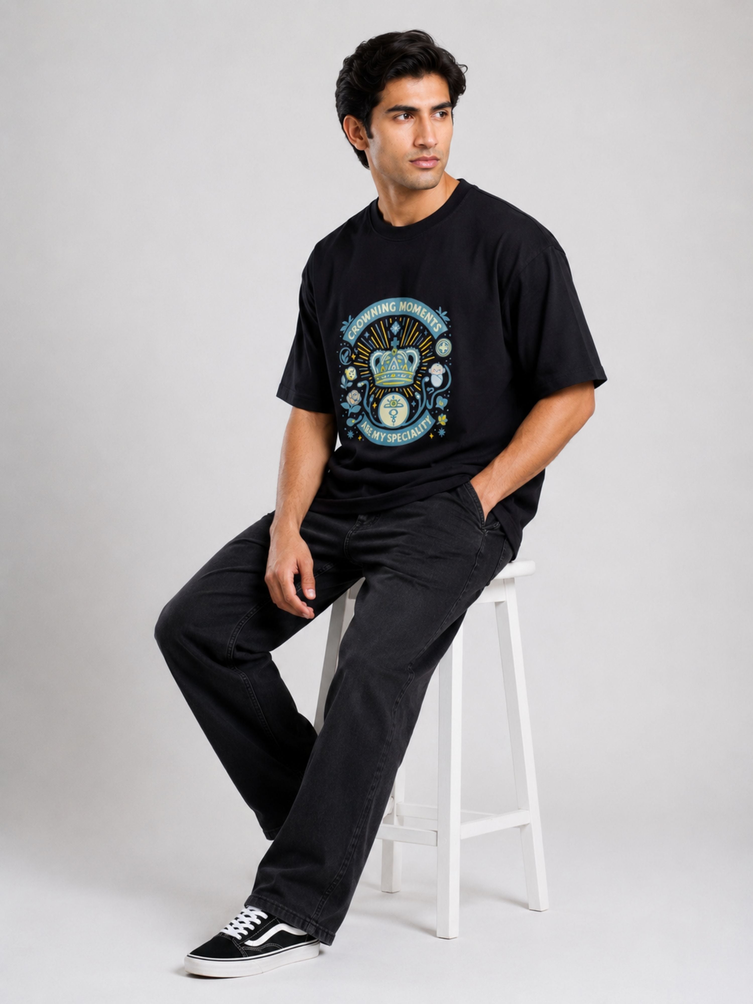 Oversized fit Gynaecologist Tshirt For Men in black with graphic print worn by a seated male model