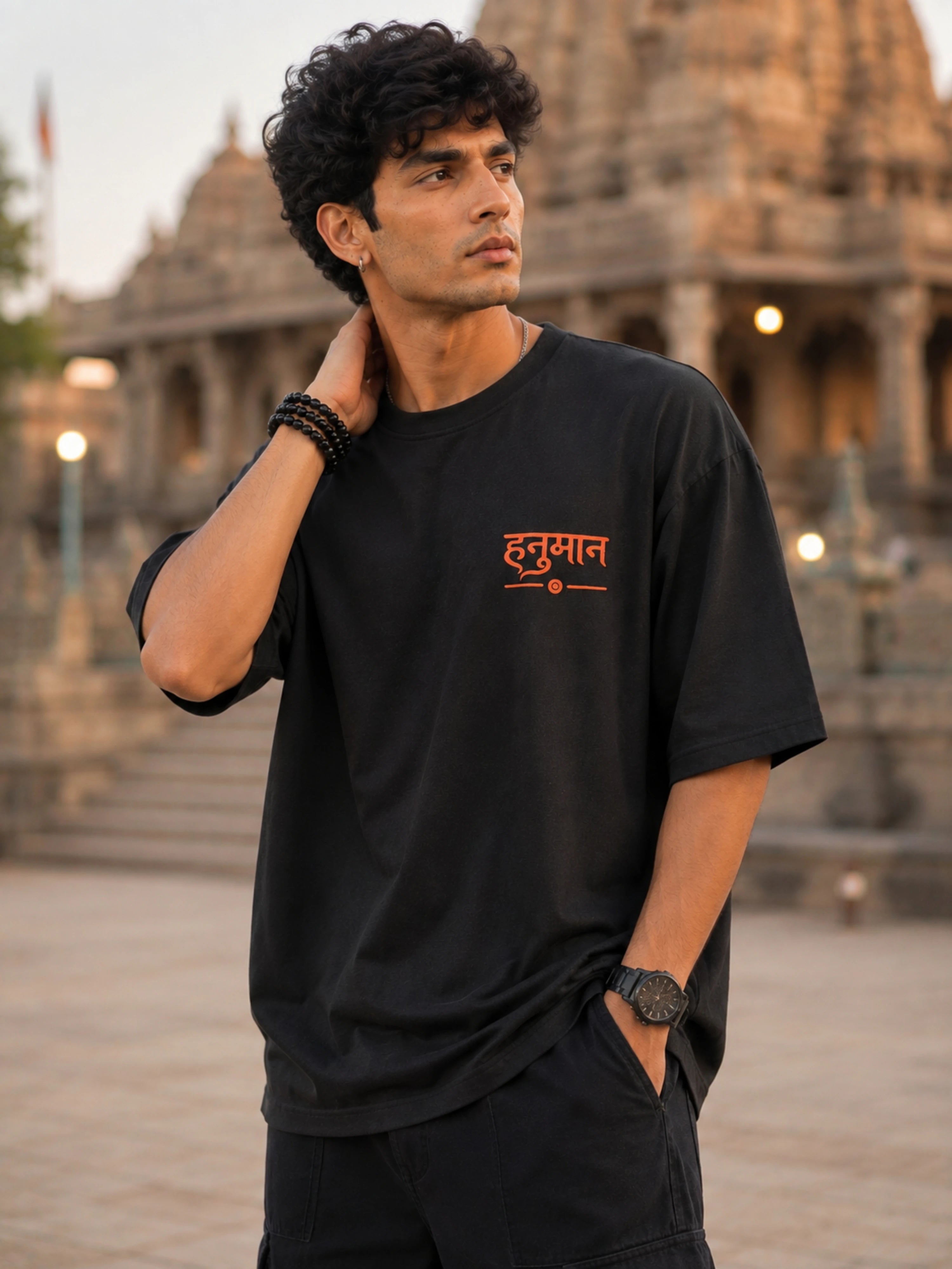 Man wearing black oversized fit HANUMAN T-shirt For Men from Bandar Baant Collections in outdoor temple setting