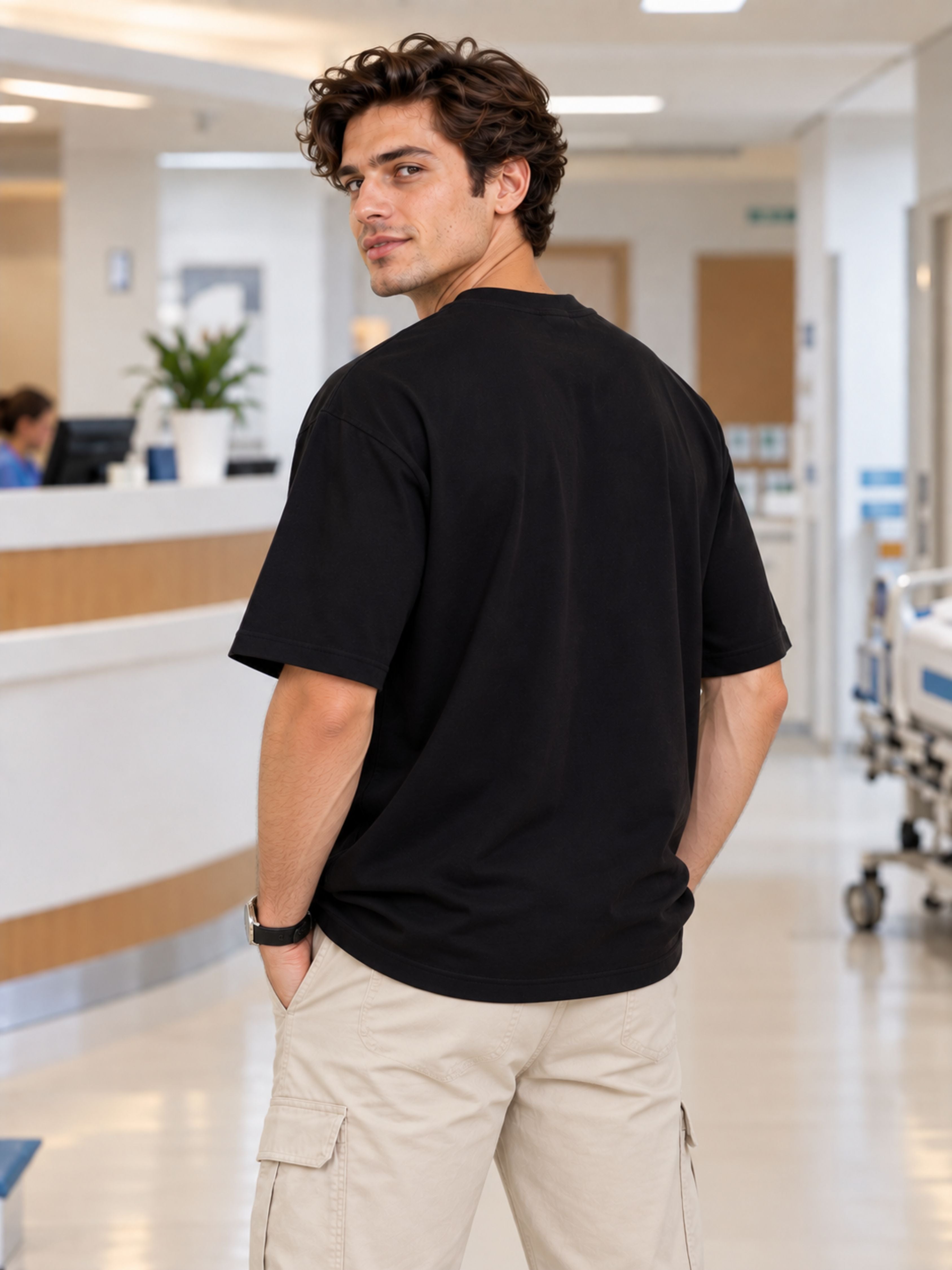 Man wearing oversized fit black Hospital Administrator Tshirt For Men in hospital setting