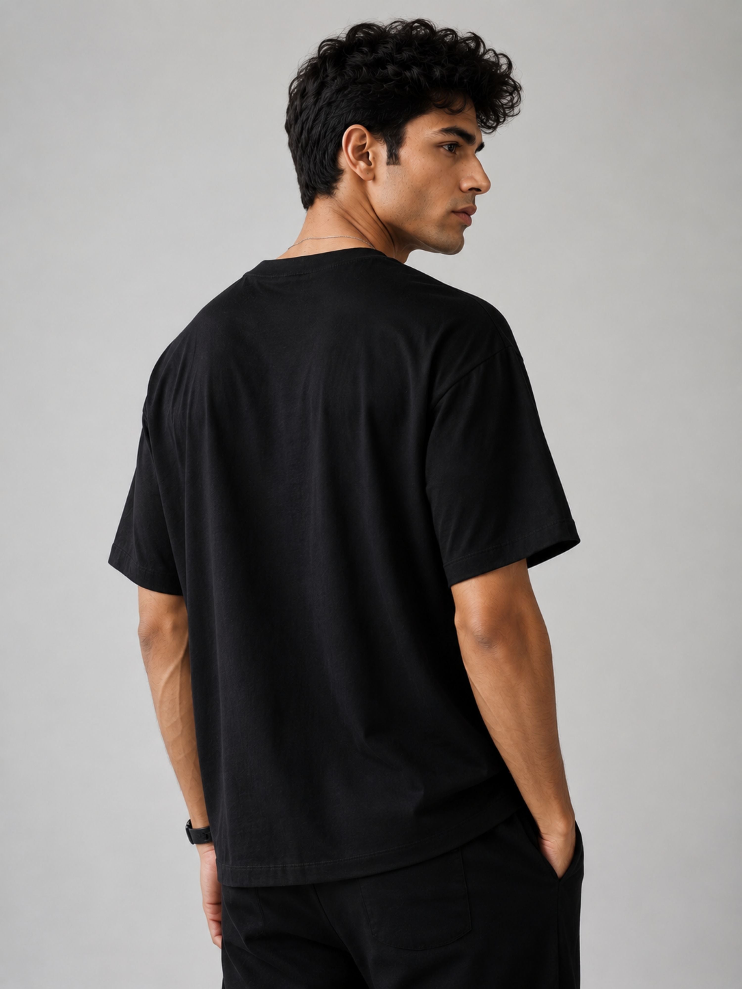 Back view of a man wearing black oversized fit Journalists T-shirt For Men by Bandar Baant Collections