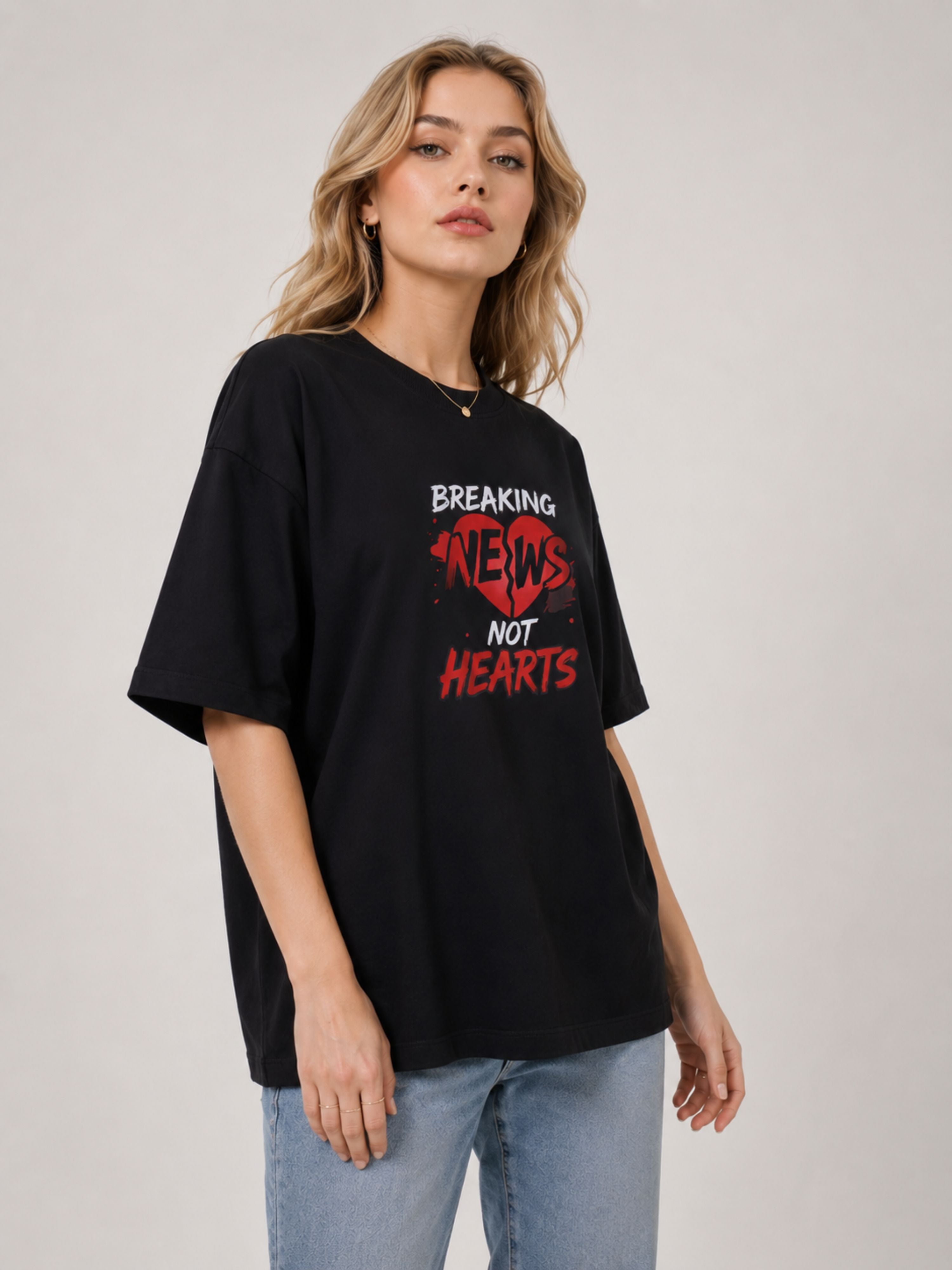 Black oversized fit Journalists T-Shirt For Women with Breaking News Not Hearts print worn with light blue jeans