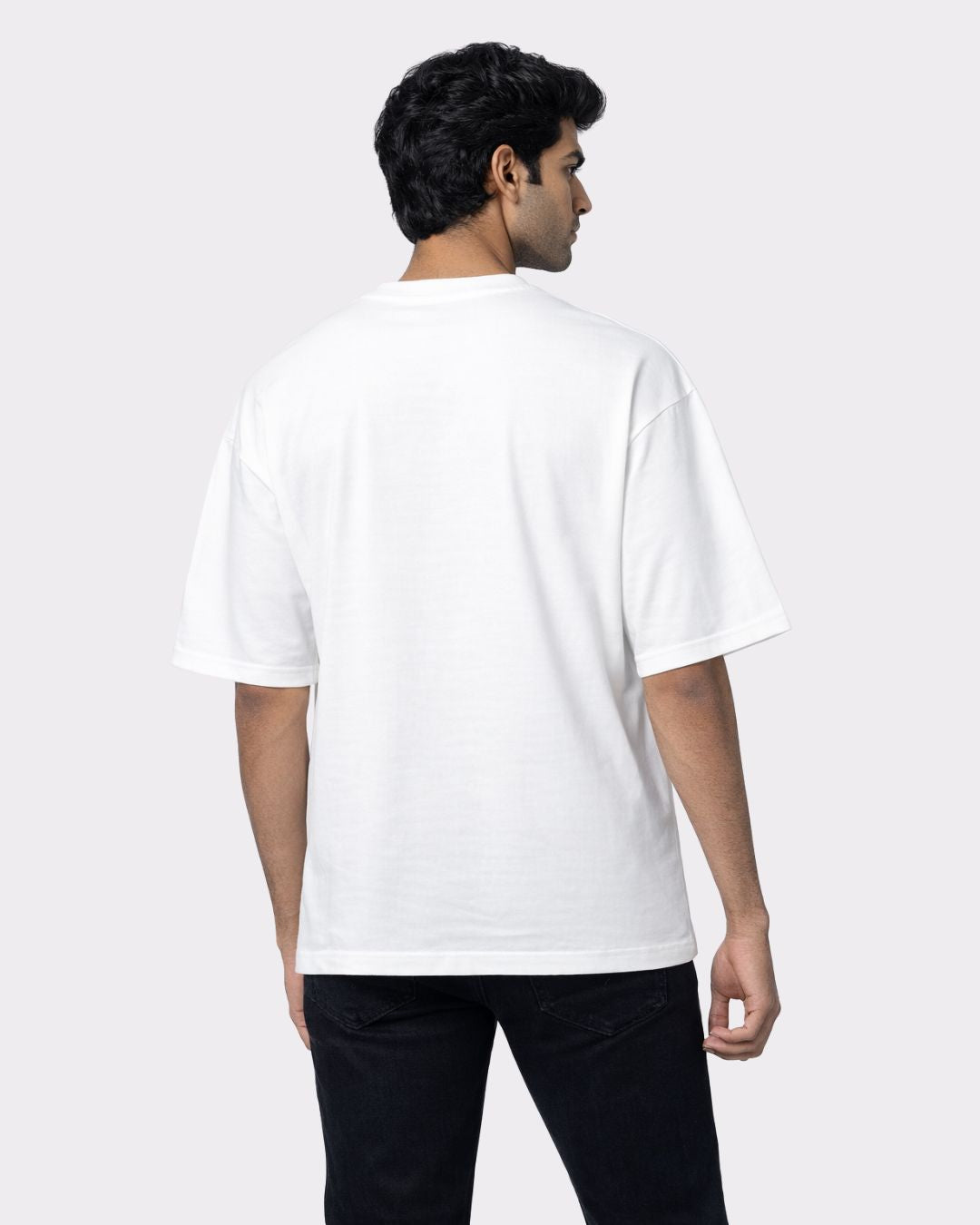 Back view of a man wearing a white Lawyer Oversized Quote T-Shirt For Men with a relaxed fit by Bandar Baant Collections