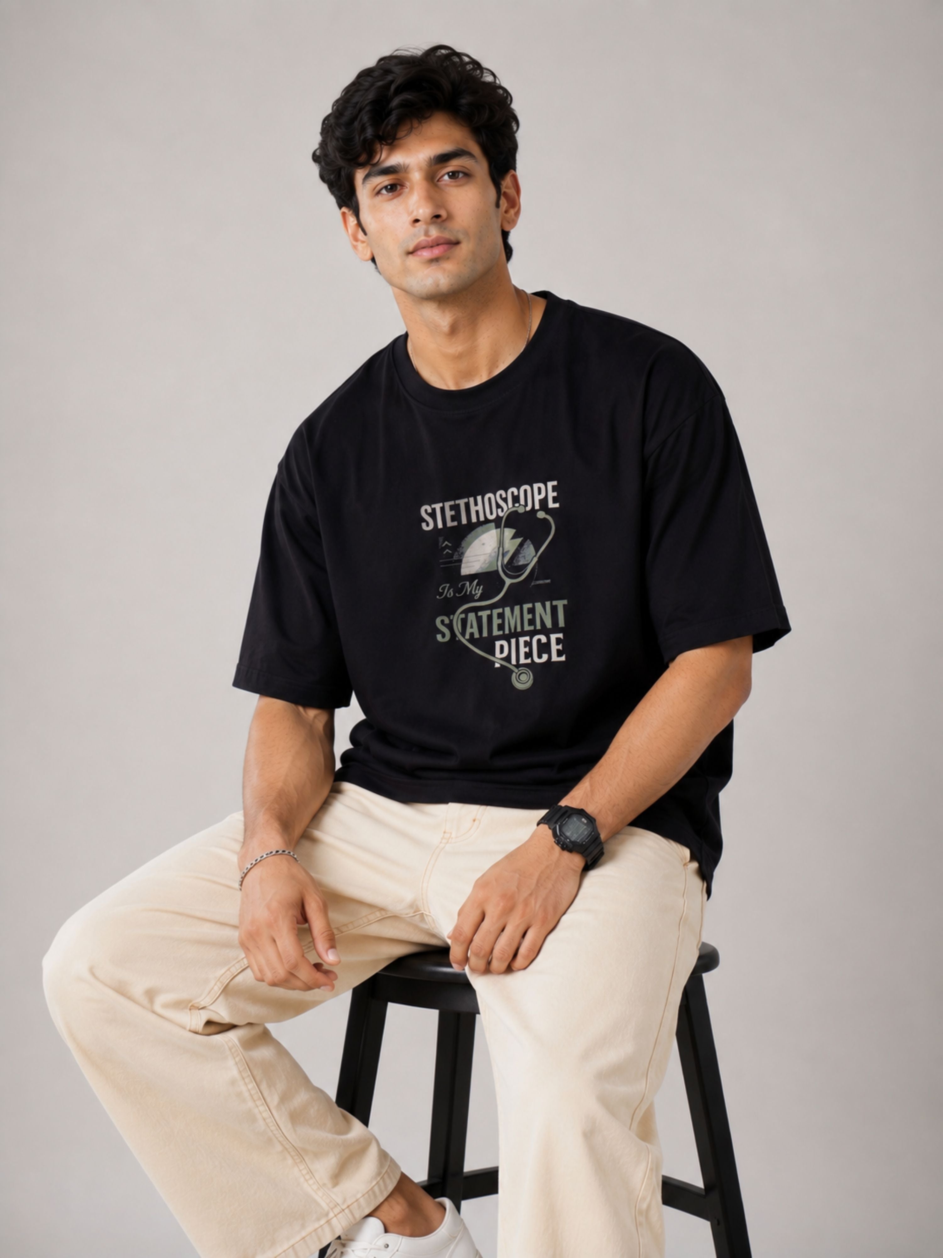 Physician Cool Printed Tshirt For Men oversized fit black t-shirt with stethoscope print worn by seated male model