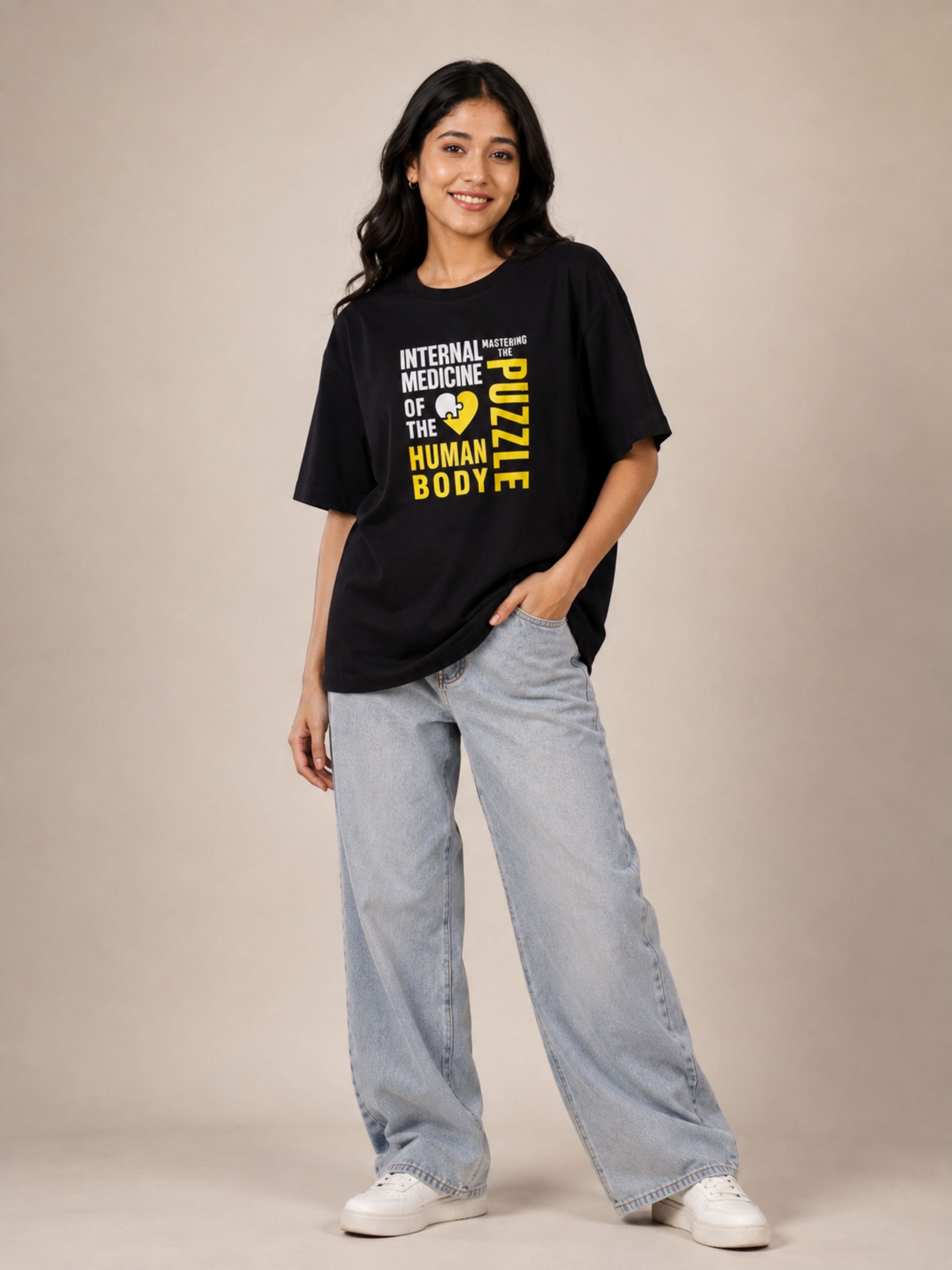 Woman wearing black oversized Physician T-shirt For Women with printed medical design paired with light blue jeans