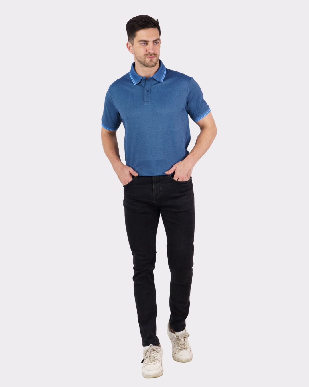 Man wearing a premium polo t-shirt for men in blue with black pants and white sneakers