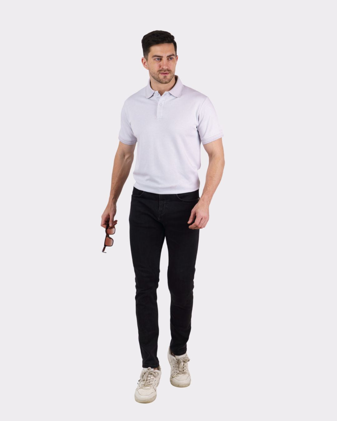 Man wearing a Premium Polo T-Shirt for Men in white paired with black jeans and white sneakers