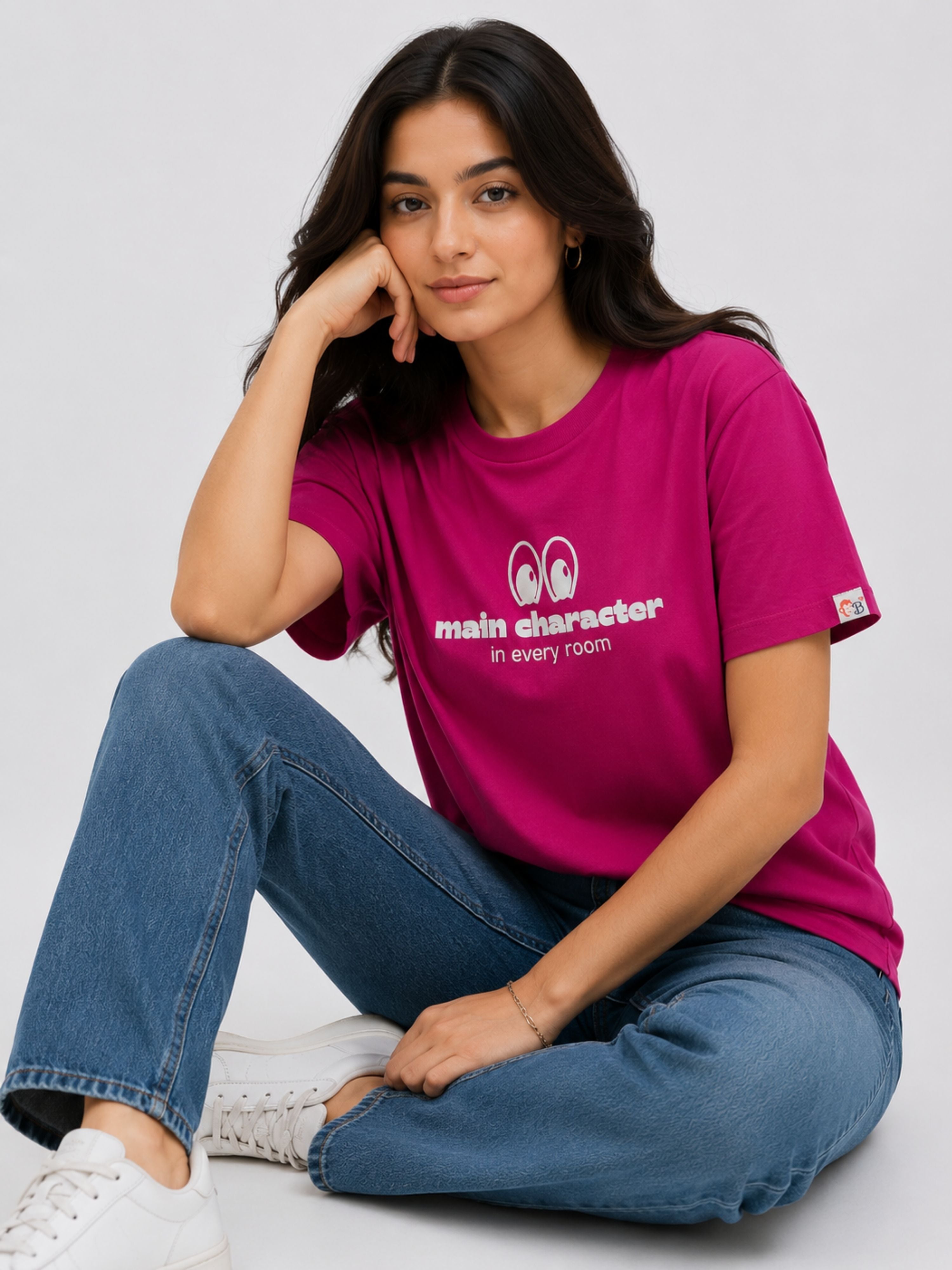 Woman wearing a magenta regular fit T-Shirt for women with main character print sitting cross-legged