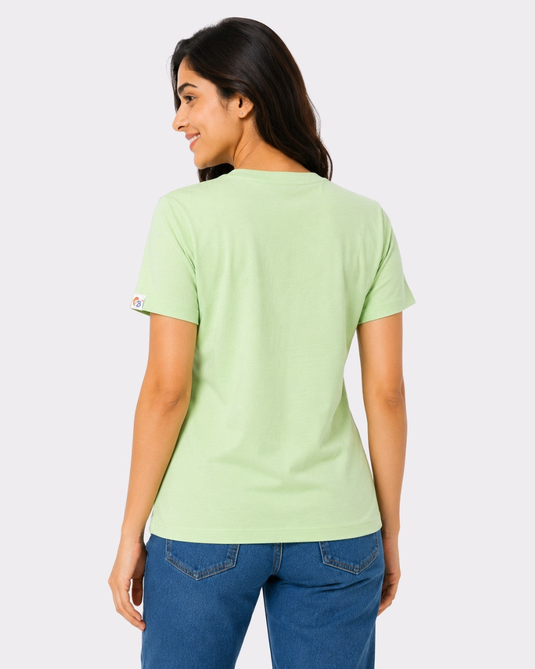 Back view of a woman wearing Regular Fit T-Shirt for Women Mint Green paired with blue jeans