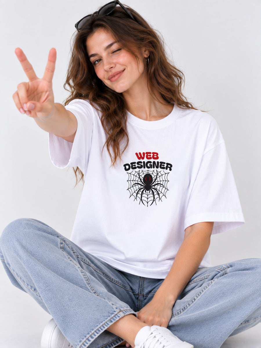 Woman wearing oversized fit Web Designer T-Shirt For Women with spider web graphic sitting cross-legged