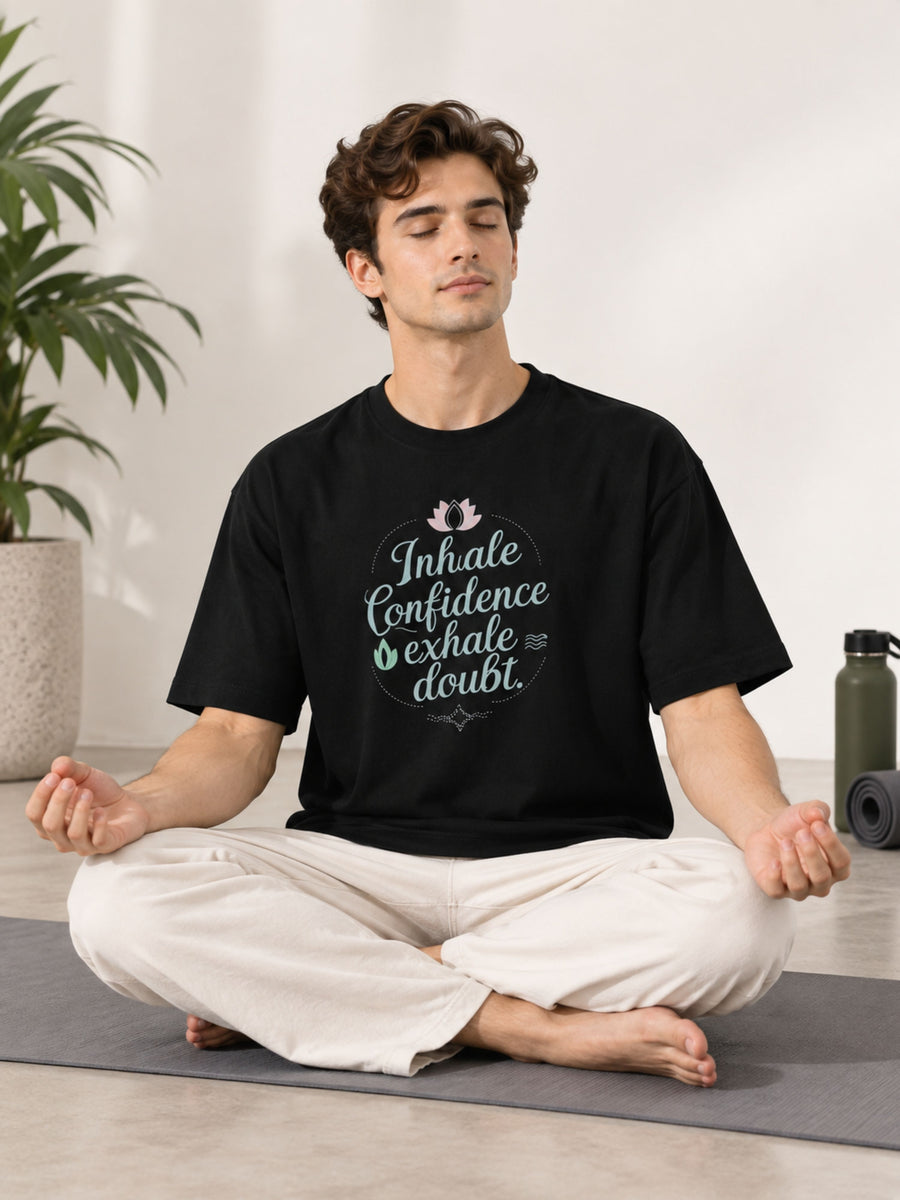 Oversized fit Yoga Instructor Tshirt For Men in black with Inhale Confidence print worn by meditating man
