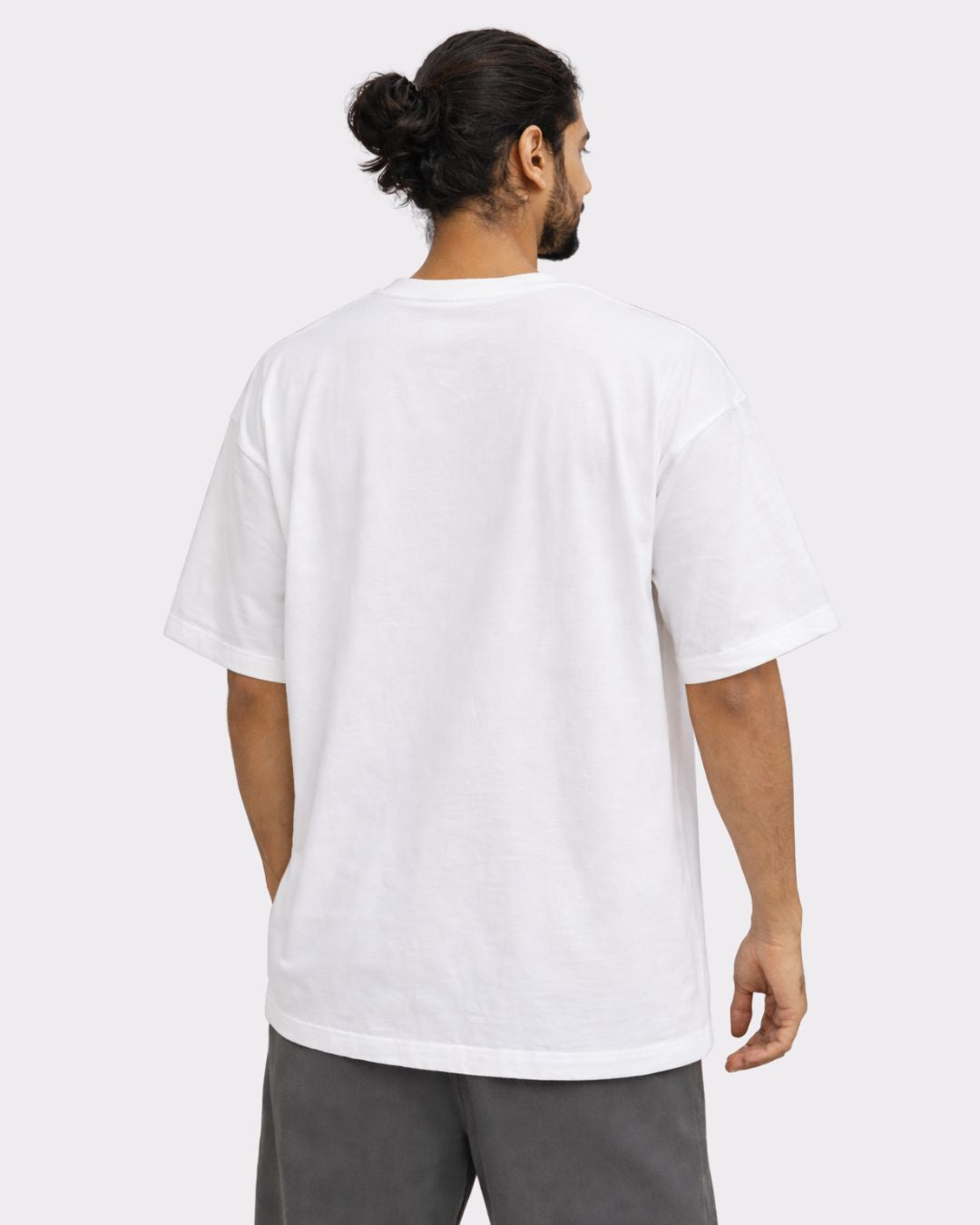 Back view of a man wearing a white Yoga Oversized Printed Tshirt For Men from Bandar Baant Collections