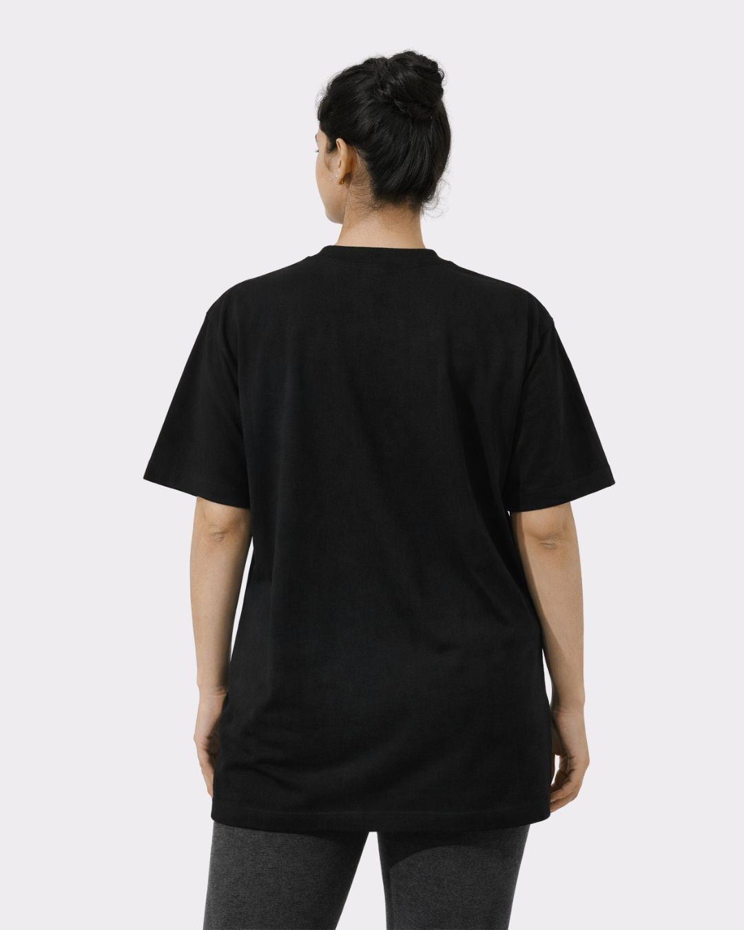 Back view of a woman wearing a black Yoga Oversized T-shirt For Women from Bandar Baant Collections